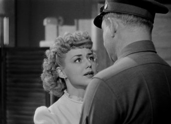 Movie still from “Bombardier” (1943), directed by Lambert Hillyer – An old black and white photo of a man and a woman; Close Up shot, Over the shoulder angle