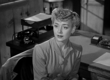 Movie still from “Bombardier” (1943), directed by Lambert Hillyer – A woman sitting at a desk in front of a phone; Close Up shot, High angle