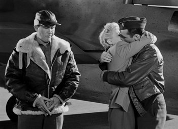 Movie still from “Bombardier” (1943), directed by Lambert Hillyer – A couple of people that are hugging in the air; Wide shot, Over the shoulder angle