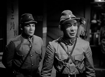 Movie still from “Bombardier” (1943), directed by Lambert Hillyer – A couple of men standing next to each other; Medium shot, Low angle