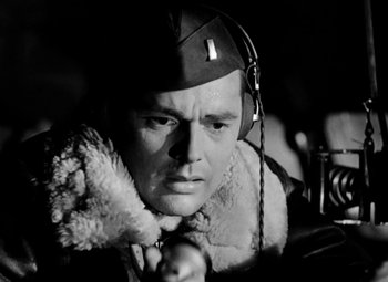 Movie still from “Bombardier” (1943), directed by Lambert Hillyer – A man wearing a hat and a fur coat; Close Up shot, Low angle