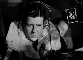 Movie still from “Bombardier” (1943), directed by Lambert Hillyer – A black and white photo of a man wearing headphones; Close Up shot, Low angle