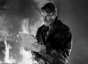 Movie still from “Bombardier” (1943), directed by Lambert Hillyer – A black and white photo of a man reading a piece of paper; Close Up shot, Over the shoulder angle