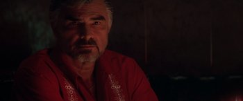 Movie still from “Boogie Nights” (1997), directed by Paul Thomas Anderson – An older man in a red shirt is looking at the camera; Close Up shot, Low angle