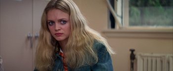 Movie still from “Boogie Nights” (1997), directed by Paul Thomas Anderson – A woman with long blonde hair sitting in a room; Close Up shot, Low angle