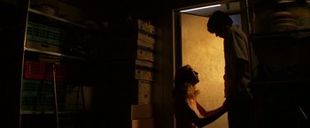 Movie still from “Boogie Nights” (1997), directed by Paul Thomas Anderson – A man and a woman are standing in a room; Medium shot, Low angle
