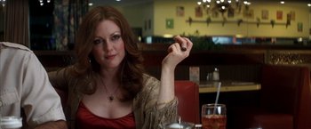 Movie still from “Boogie Nights” (1997), directed by Paul Thomas Anderson – A woman sitting at a table in front of a drink; Close Up shot, Over the shoulder angle