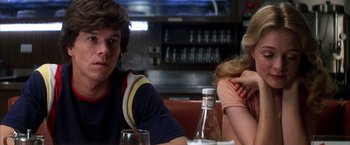 Movie still from “Boogie Nights” (1997), directed by Paul Thomas Anderson – A man and a woman sitting at a table in a restaurant; Close Up shot, Over the shoulder angle