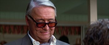 Movie still from “Boogie Nights” (1997), directed by Paul Thomas Anderson – An older man wearing glasses and wearing a suit; Close Up shot, Over the shoulder angle