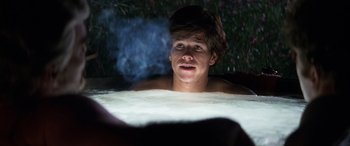 Movie still from “Boogie Nights” (1997), directed by Paul Thomas Anderson – A young man is in a hot tub at night; Medium shot, Over the shoulder angle