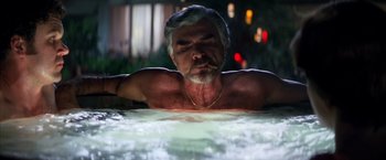 Movie still from “Boogie Nights” (1997), directed by Paul Thomas Anderson – An older man is laying in a hot tub at night; Medium shot, Low angle