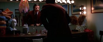 Movie still from “Boogie Nights” (1997), directed by Paul Thomas Anderson – A man in a dressing room looking at himself in the mirror; Medium shot, Low angle