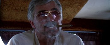 Movie still from “Boogie Nights” (1997), directed by Paul Thomas Anderson – An older man smoking a cigar while sitting in a car; Close Up shot, Low angle