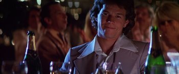 Movie still from “Boogie Nights” (1997), directed by Paul Thomas Anderson – A man sitting in front of a group of wine glasses; Close Up shot, Over the shoulder angle