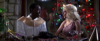 Movie still from “Boogie Nights” (1997), directed by Paul Thomas Anderson – A man and a woman are talking to each other at a party; Medium shot, Over the shoulder angle