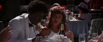 Movie still from “Boogie Nights” (1997), directed by Paul Thomas Anderson – A man and a woman sitting at a table with wine glasses; Close Up shot, Over the shoulder angle