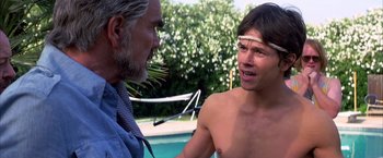 Movie still from “Boogie Nights” (1997), directed by Paul Thomas Anderson – A man and a boy talking next to a swimming pool; Close Up shot, Over the shoulder angle