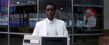 Movie still from “Boogie Nights” (1997), directed by Paul Thomas Anderson – A man in a white suit and tie standing in front of a computer; Close Up shot, Low angle