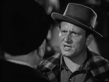Movie still from “Boom Town” (1940), directed by Jack Conway – A man wearing a hat talking to another man in front of a building; Close Up shot, Over the shoulder angle