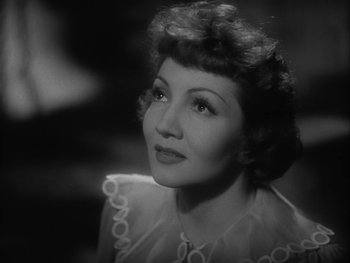 Movie still from “Boom Town” (1940), directed by Jack Conway – An old photo of a woman in a white dress looking to her left; Close Up shot, High angle