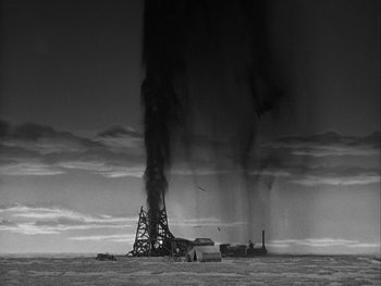 Movie still from “Boom Town” (1940), directed by Jack Conway – An oil rig is spewing smoke into the air; Extreme Wide shot, Low angle