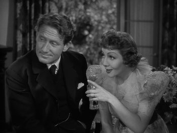 Movie still from “Boom Town” (1940), directed by Jack Conway – A man and a woman sitting next to each other holding a drink; Medium shot, High angle