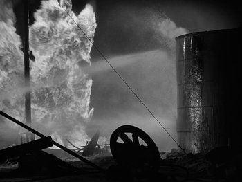 Movie still from “Boom Town” (1940), directed by Jack Conway – A fire is burning in the middle of the night; Wide shot, Low angle