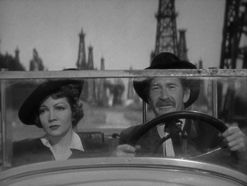Movie still from “Boom Town” (1940), directed by Jack Conway – An old photo of a man and a woman in a car; Medium shot, Low angle