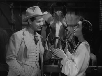 Movie still from “Boom Town” (1940), directed by Jack Conway – A man and a woman standing next to a horse; Medium shot, High angle