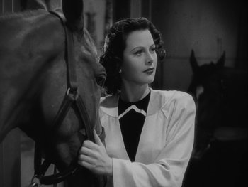 Movie still from “Boom Town” (1940), directed by Jack Conway – A black and white photo of a woman and a horse; Close Up shot, Low angle