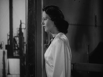Movie still from “Boom Town” (1940), directed by Jack Conway – A woman standing in front of a window; Medium shot, Over the shoulder angle