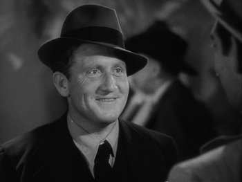 Movie still from “Boom Town” (1940), directed by Jack Conway – A man wearing a hat and a suit and tie; Close Up shot, High angle