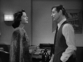 Movie still from “Boom Town” (1940), directed by Jack Conway – A man and a woman standing next to each other in a room; Medium shot, Over the shoulder angle