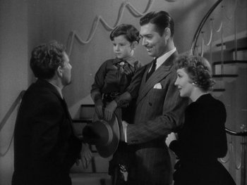 Movie still from “Boom Town” (1940), directed by Jack Conway – An old photo of a man holding a young boy; Medium shot, High angle