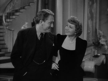 Movie still from “Boom Town” (1940), directed by Jack Conway – An older man standing next to an older woman in front of a staircase; Medium shot, High angle