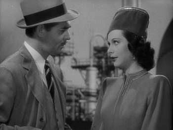 Movie still from “Boom Town” (1940), directed by Jack Conway – A man and a woman wearing hats and talking to each other; Close Up shot, Over the shoulder angle