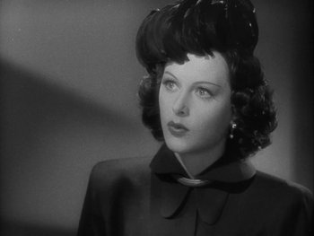 Movie still from “Boom Town” (1940), directed by Jack Conway – A black and white photo of a woman in a black coat; Close Up shot, Low angle