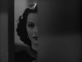 Movie still from “Boom Town” (1940), directed by Jack Conway – A black - and - white photo of a woman looking at the camera; Close Up shot, Over the shoulder angle