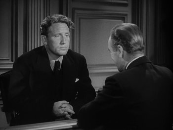 Movie still from “Boom Town” (1940), directed by Jack Conway – A man sitting in front of a mirror talking to another man; Medium shot, Over the shoulder angle