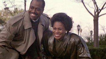Movie still from “Boomerang” (1992), directed by Reginald Hudlin – A man and a woman smiling for the camera; Medium shot, Low angle