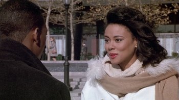 Movie still from “Boomerang” (1992), directed by Reginald Hudlin – A woman wearing a white coat and a scarf; Close Up shot, Over the shoulder angle