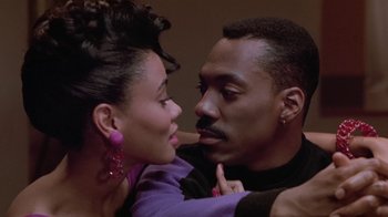 Movie still from “Boomerang” (1992), directed by Reginald Hudlin – A man and a woman embracing each other in front of a wall; Close Up shot, Low angle