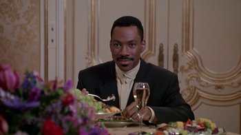 Movie still from “Boomerang” (1992), directed by Reginald Hudlin – A man sitting at a dinner table with a glass of wine; Medium shot, Over the shoulder angle