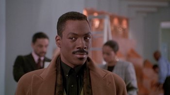 Movie still from “Boomerang” (1992), directed by Reginald Hudlin – A person wearing a suit and tie; Close Up shot, Over the shoulder angle