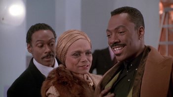Movie still from “Boomerang” (1992), directed by Reginald Hudlin – A group of people standing next to each other; Close Up shot, Over the shoulder angle