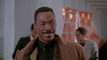 Movie still from “Boomerang” (1992), directed by Reginald Hudlin – A person wearing a suit and tie; Close Up shot, Over the shoulder angle