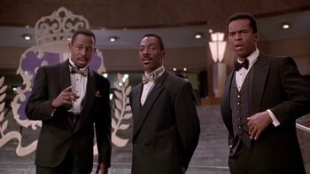 Movie still from “Boomerang” (1992), directed by Reginald Hudlin – A group of men standing next to each other in tuxedos; Medium shot, Low angle