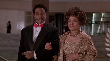 Movie still from “Boomerang” (1992), directed by Reginald Hudlin – A man and a woman standing next to each other in formal wear; Medium shot, Low angle