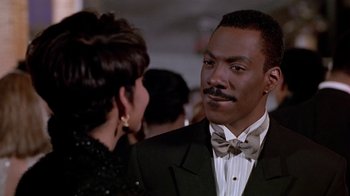 Movie still from “Boomerang” (1992), directed by Reginald Hudlin – A man in a suit and bow tie talking to a woman in a black dress; Close Up shot, Over the shoulder angle