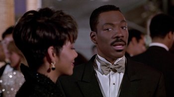 Movie still from “Boomerang” (1992), directed by Reginald Hudlin – A man and a woman are standing next to each other; Close Up shot, Over the shoulder angle